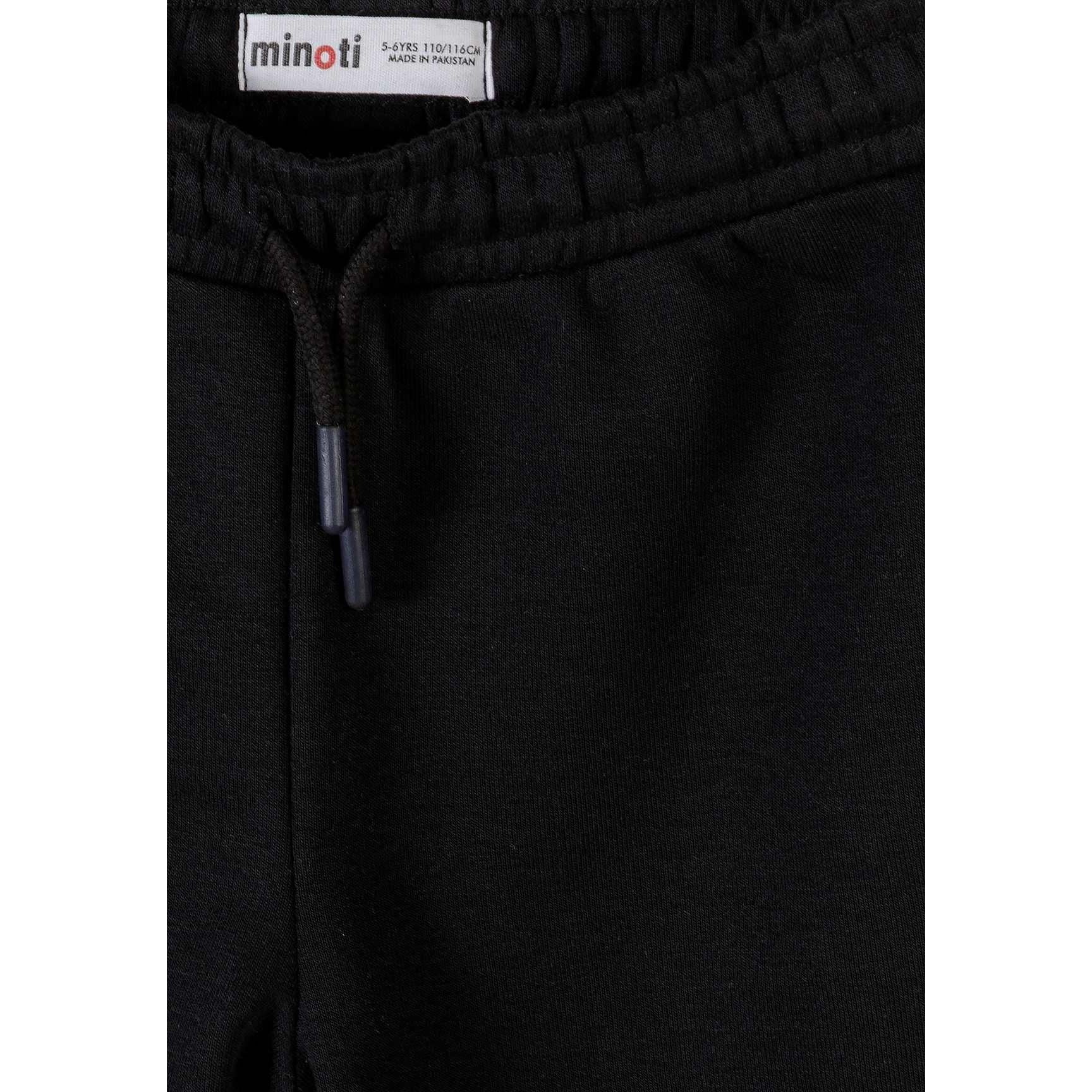 Close-up detail of black jogger waistband showing Minoti label and drawstring with cord ends