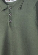 Detail of a boys' long sleeve knitted polo shirt in deep forest with a classic collar and buttoned placket.