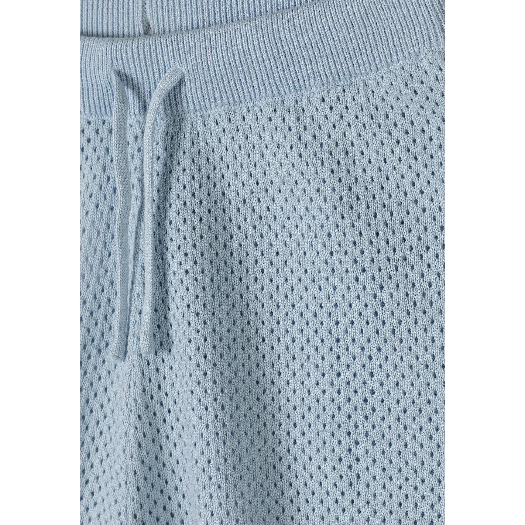 Close-up detail of light blue knitted shorts showing mesh texture, elasticated waistband with drawstring ties