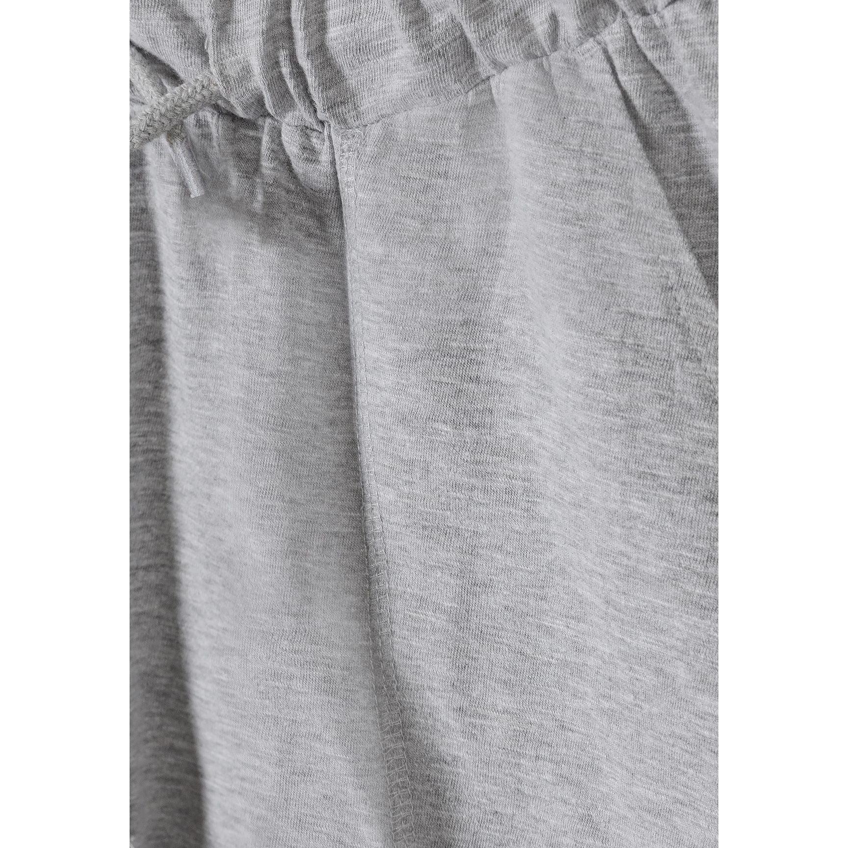 Close-up detail of grey cotton slub jersey fabric showing texture and elasticated waistband with drawstring tie