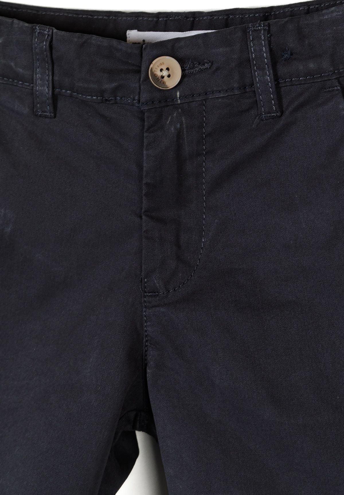 Close-up of navy chino shorts with button closure and belt loops.