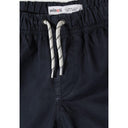 Detail shot of navy shorts waistband showing Minoti brand label and white drawstring with navy pattern against fabric texture