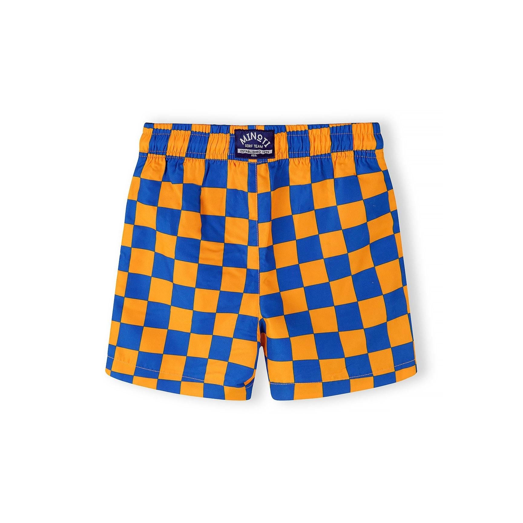 Close-up detail of orange and blue checkerboard pattern swim shorts showing elastic waistband with white drawstring cord
