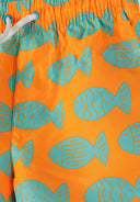 Close-up of vibrant orange swim shorts featuring a unique turquoise fish print design for kids.
