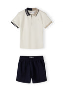 Boys cream pique polo shirt with black collar, short sleeves, and zip.