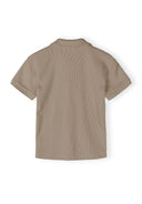 Boys polo shirt in muted sand, back view, classic collar and short sleeves.