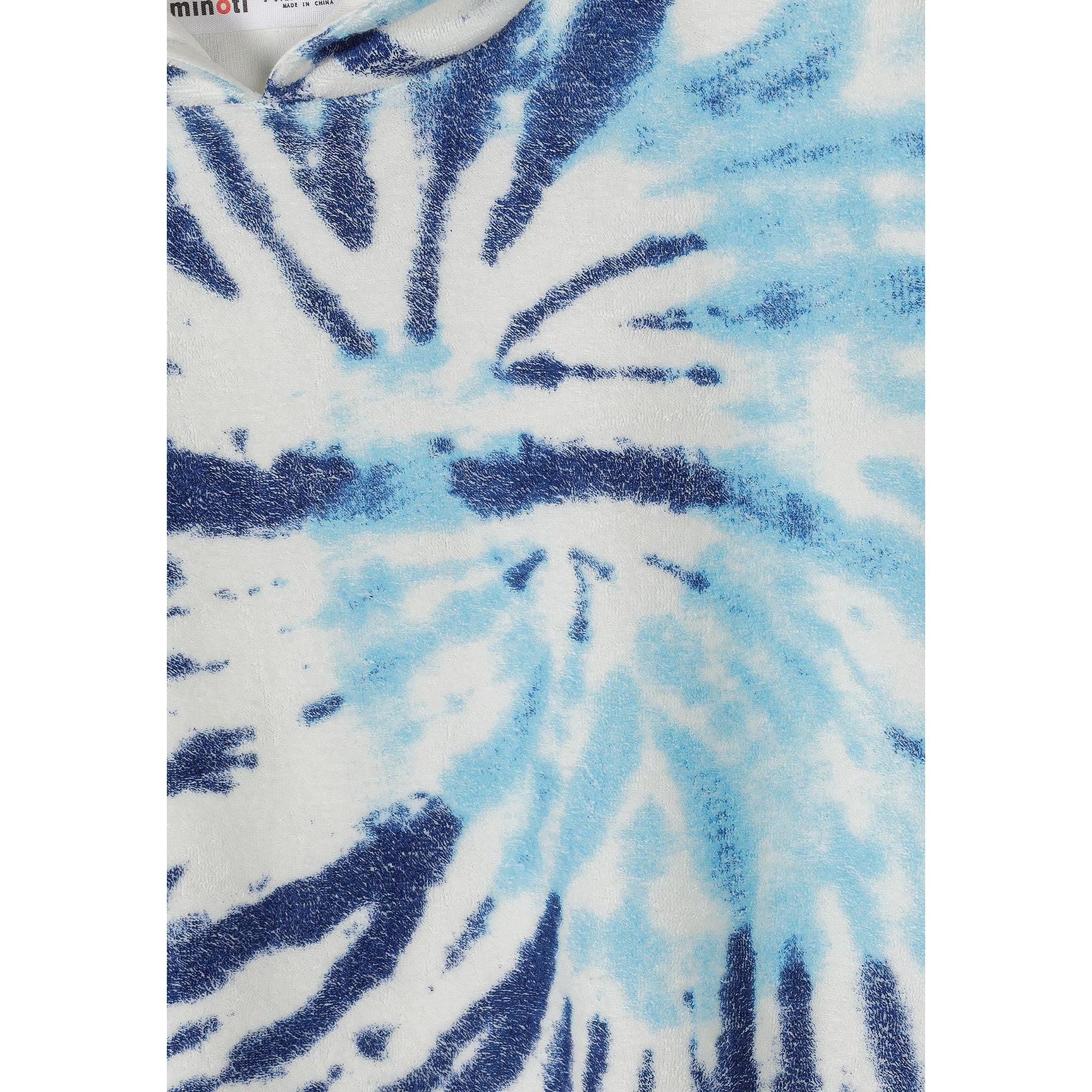 Close-up detail of blue and white tie-dye pattern on terry towelling fabric with Minoti label visible