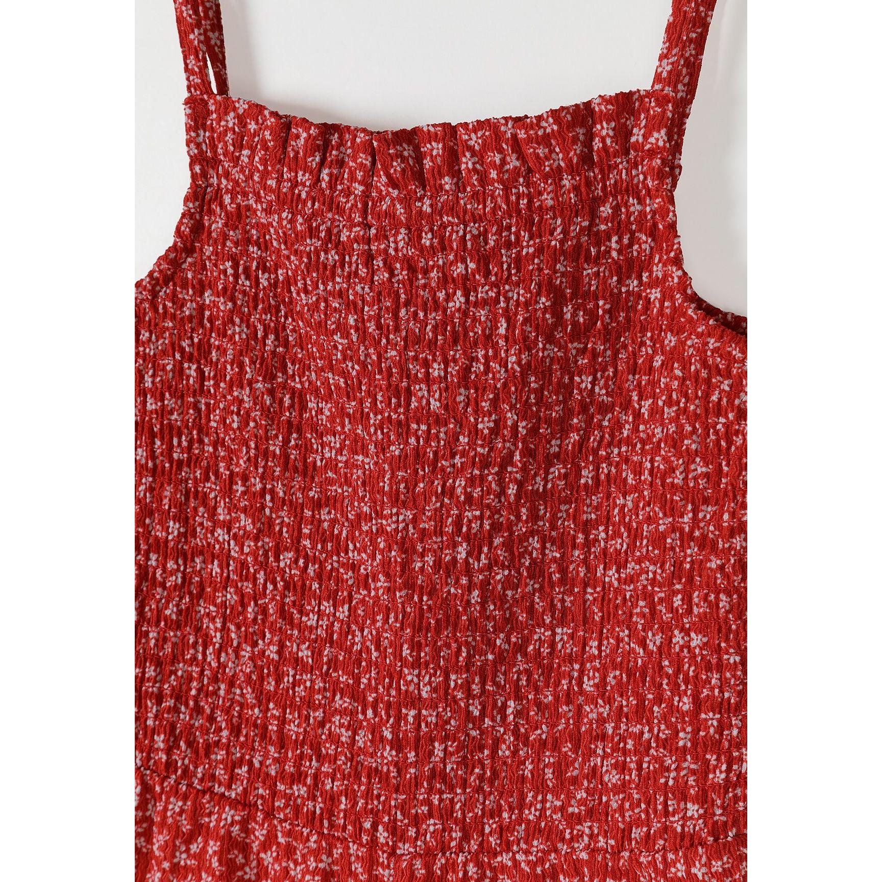 Close-up detail of red and white floral print fabric with shirred elastic gathering on jumpsuit bodice