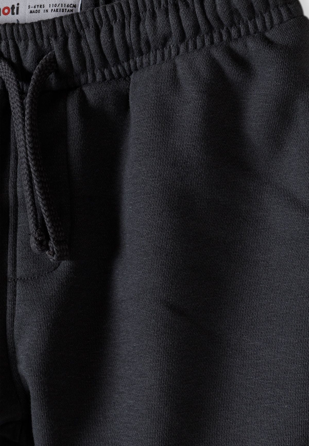Detail of grey shorts with elasticated waistband and drawstring.