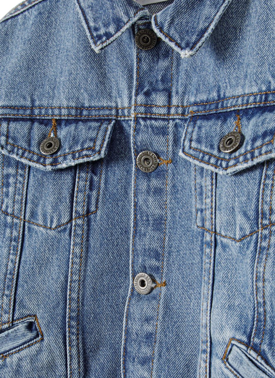 Close-up of a boys denim jacket in navy with button fastening and flap pockets.
