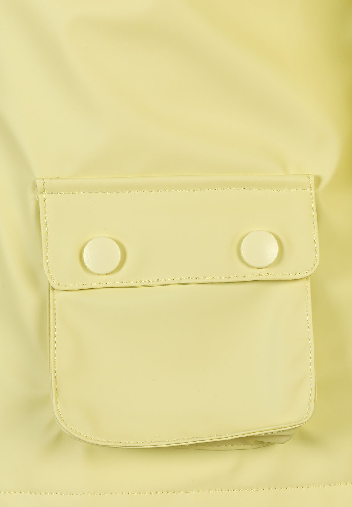 Close-up of the pocket on the yellow hooded jacket.