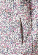 Detail of a girls softshell jacket with floral print and front pocket.