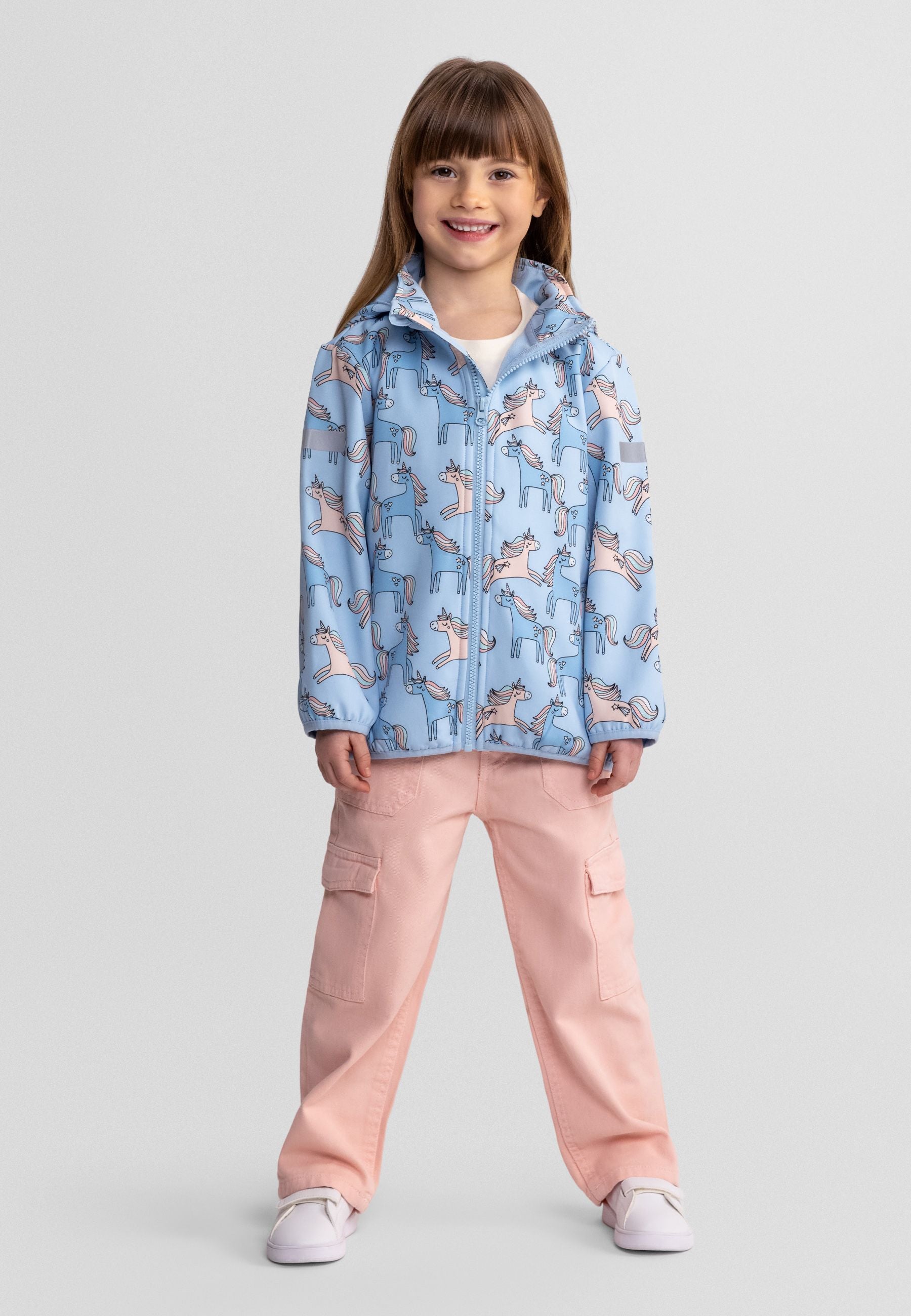 Front view of a girls' light blue softshell jacket with unicorn print and full-length zip.