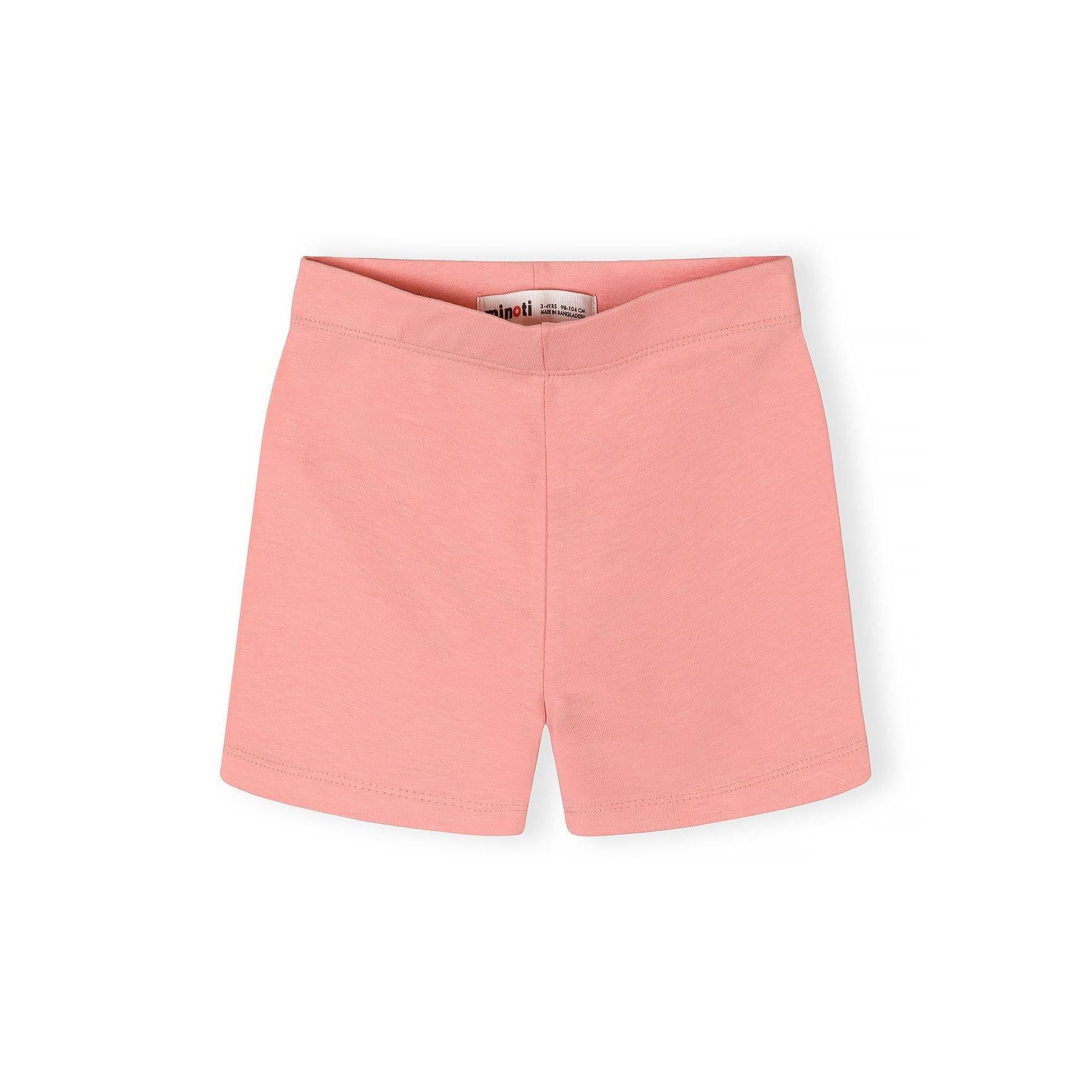 Close-up detail of coral pink cycle shorts showing Minoti brand label inside waistband and soft cotton stretch fabric texture