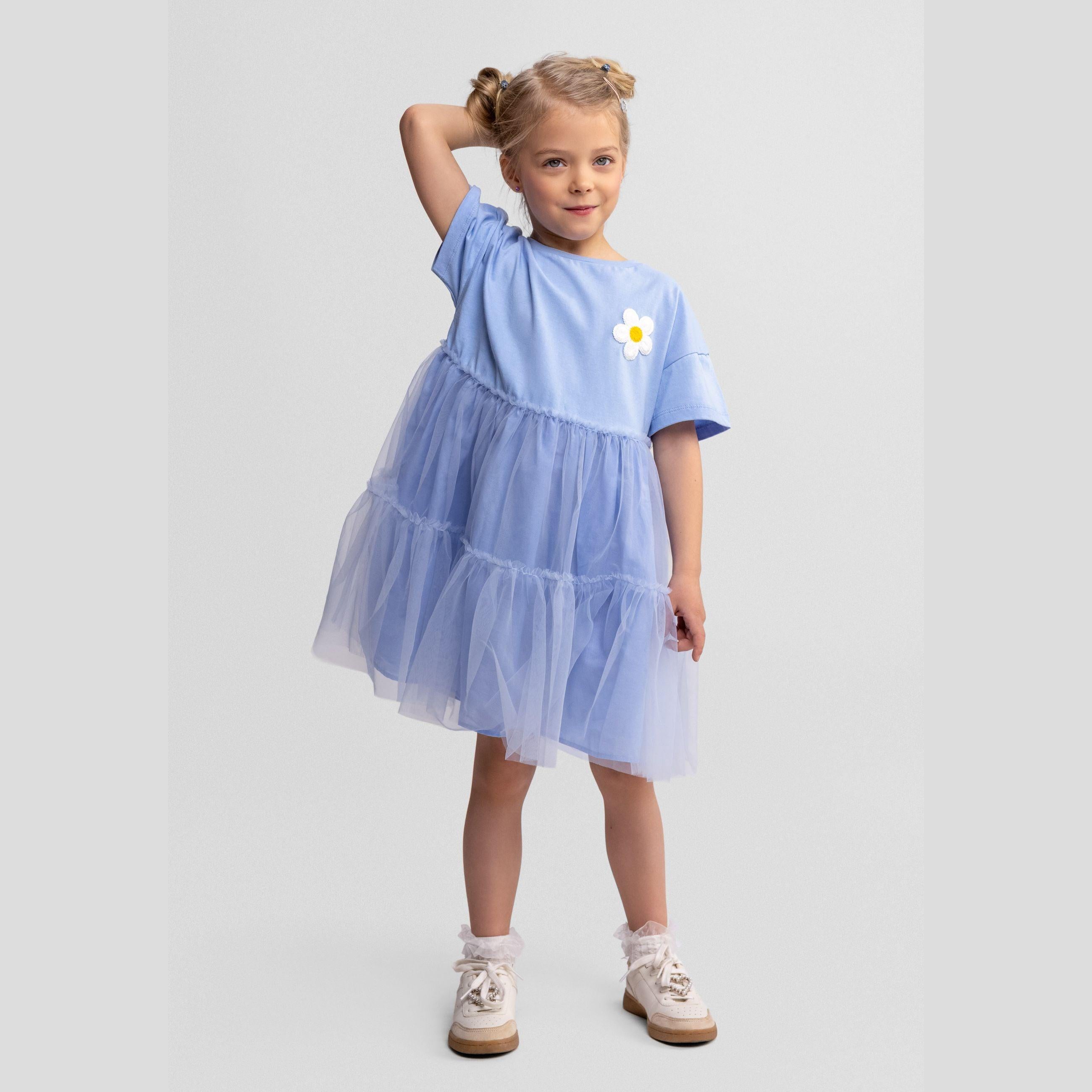 Back view of blue cotton and tulle dress showing layered skirt construction and short sleeves on white background