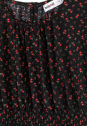 Detail of a girls' black floral dress with frill sleeves and round neckline.