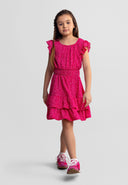 Young girl wearing pink floral dress with frill sleeves and tiered skirt, showcasing elegant kids fashion style