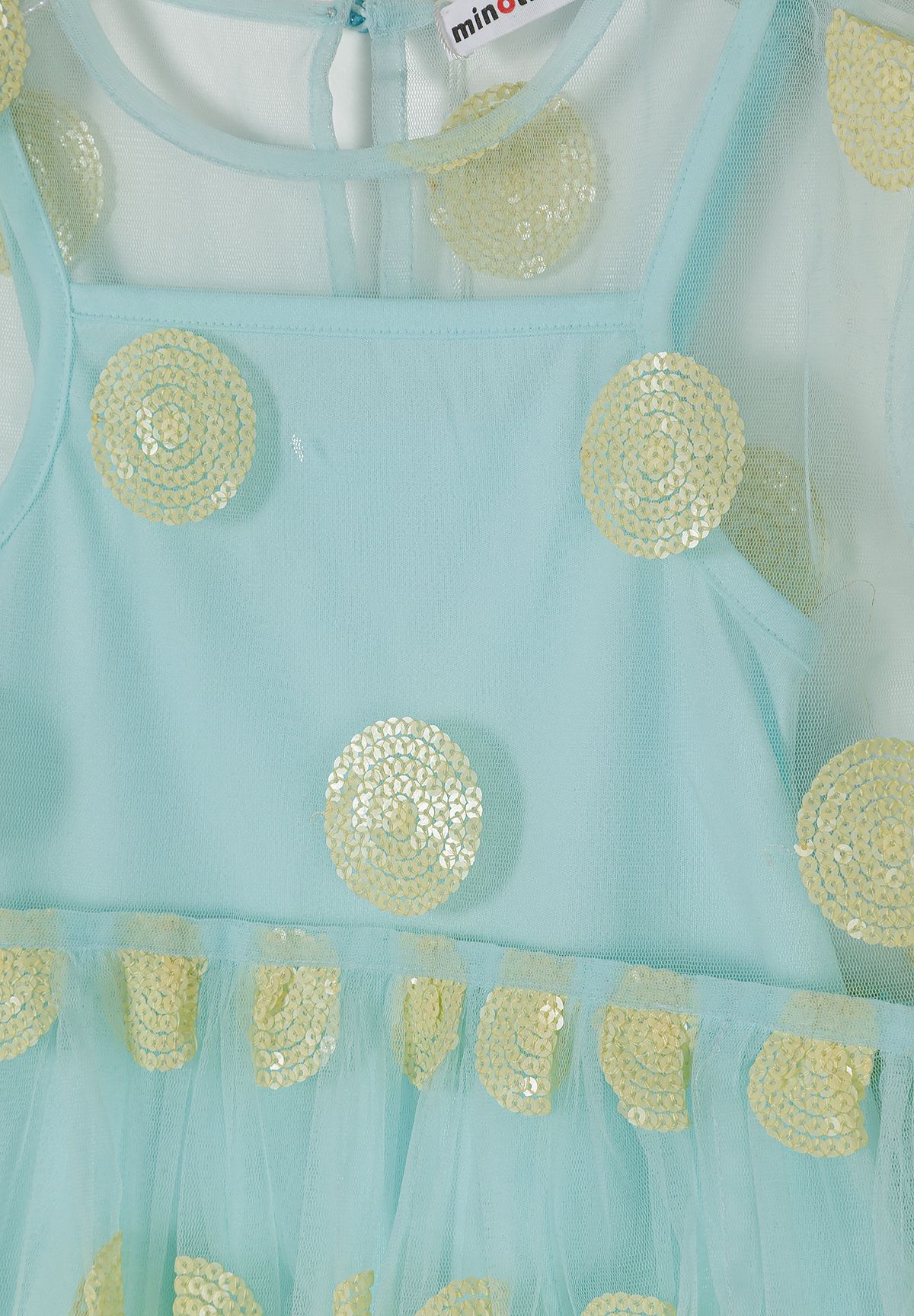 Close-up detail of turquoise tulle fabric showing gold sequin polka dot pattern, layered construction, and Minoti brand label