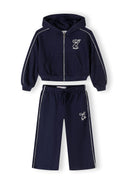 Navy blue girls' tracksuit, front view, features zip-up jacket with hood and side pockets.