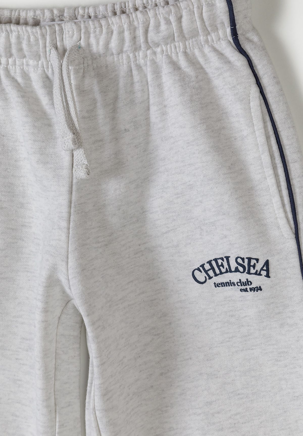 Detail of grey marl jogging trousers with adjustable waistband and logo.