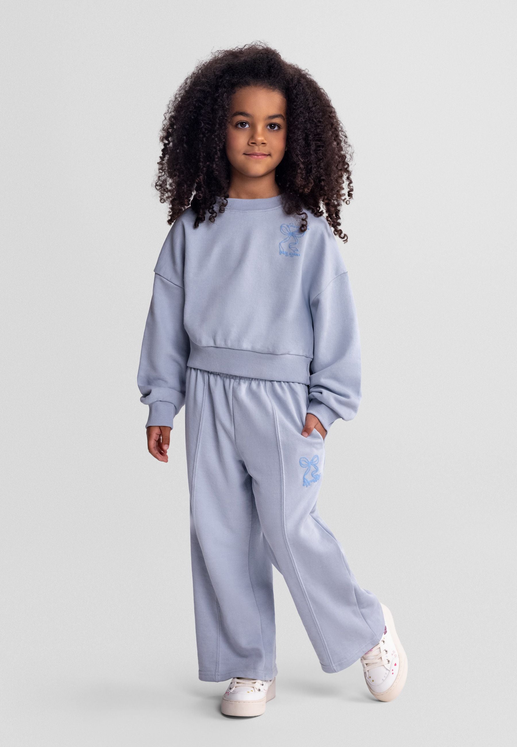 Light blue girls' tracksuit with wide-leg trousers and hooded jacket, front view.