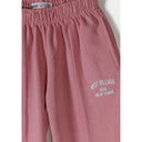 Detail shot showing Minoti brand label and elastic waistband construction of pink wide-leg joggers with text print