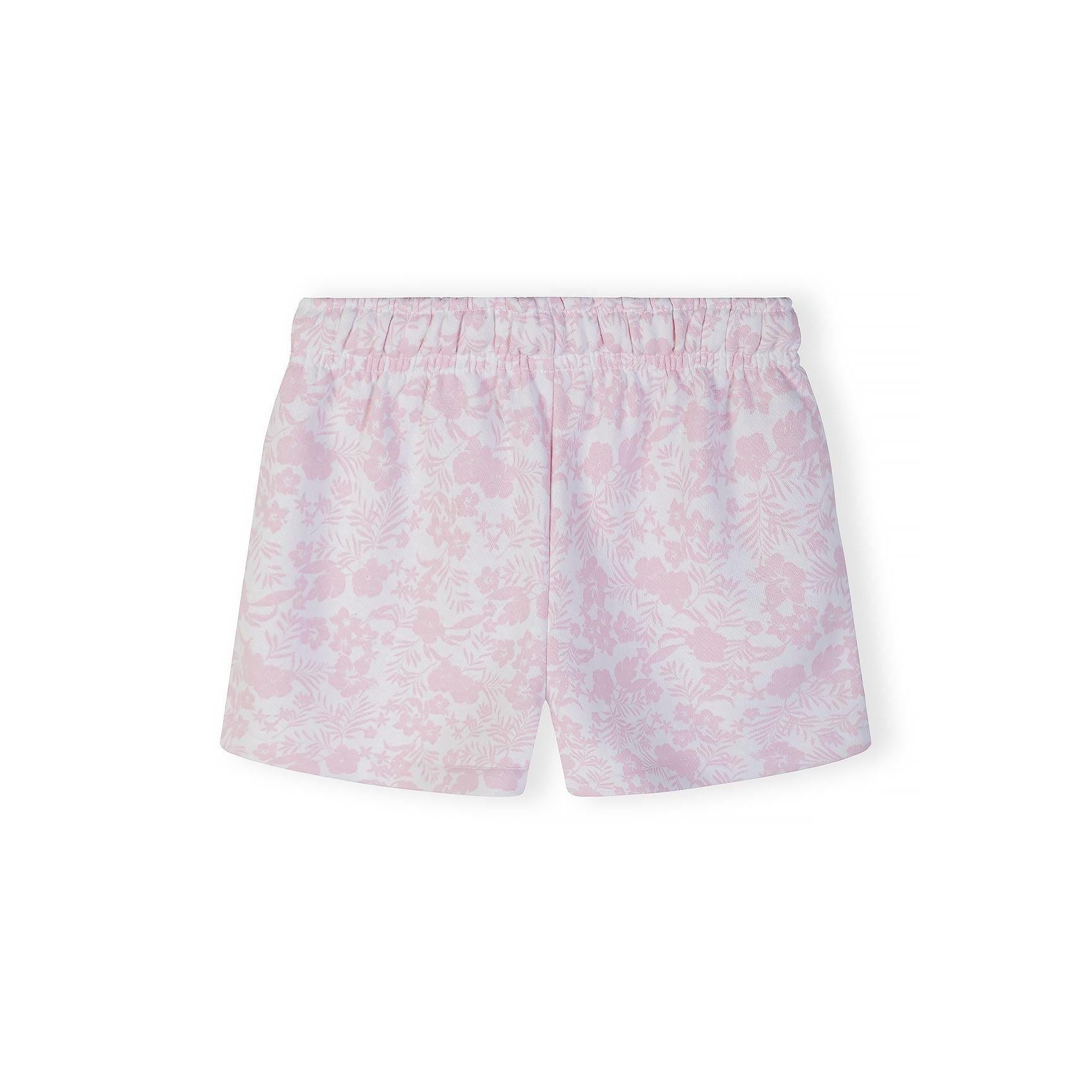 Close-up detail of tropical floral print pattern in pink and white with small pink palm tree embroidery visible on fabric