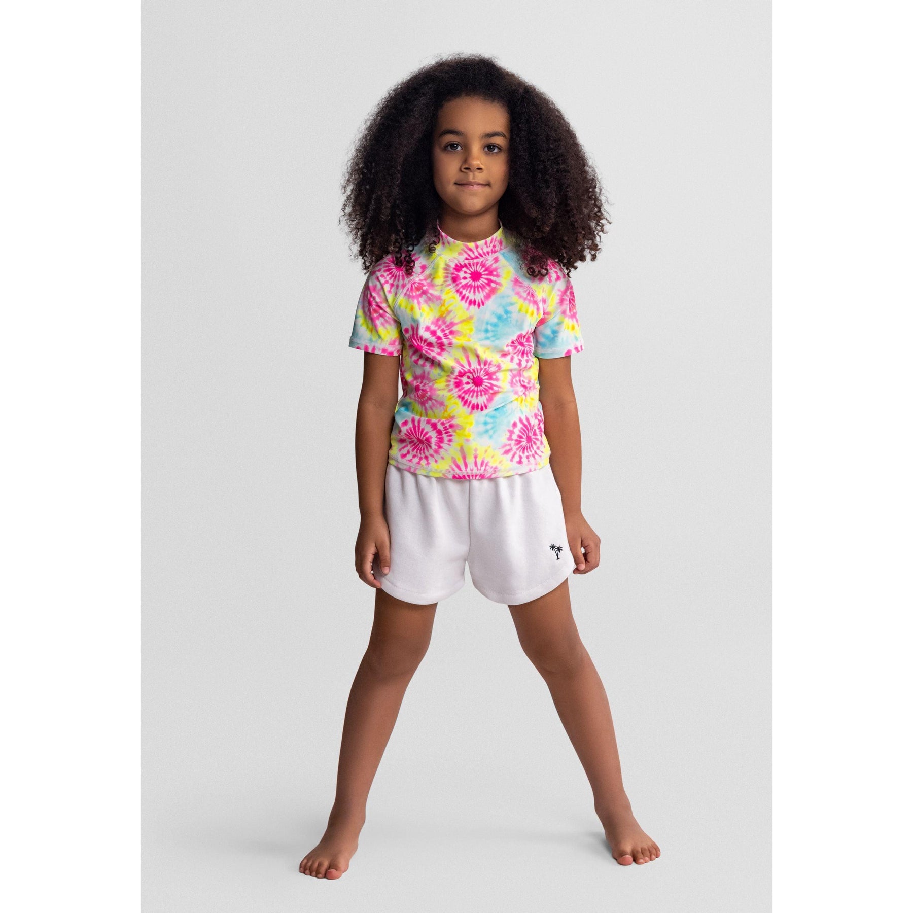 Single pink shorts with elastic waistband, white drawstring bow and small pink palm tree embroidery on leg against white background