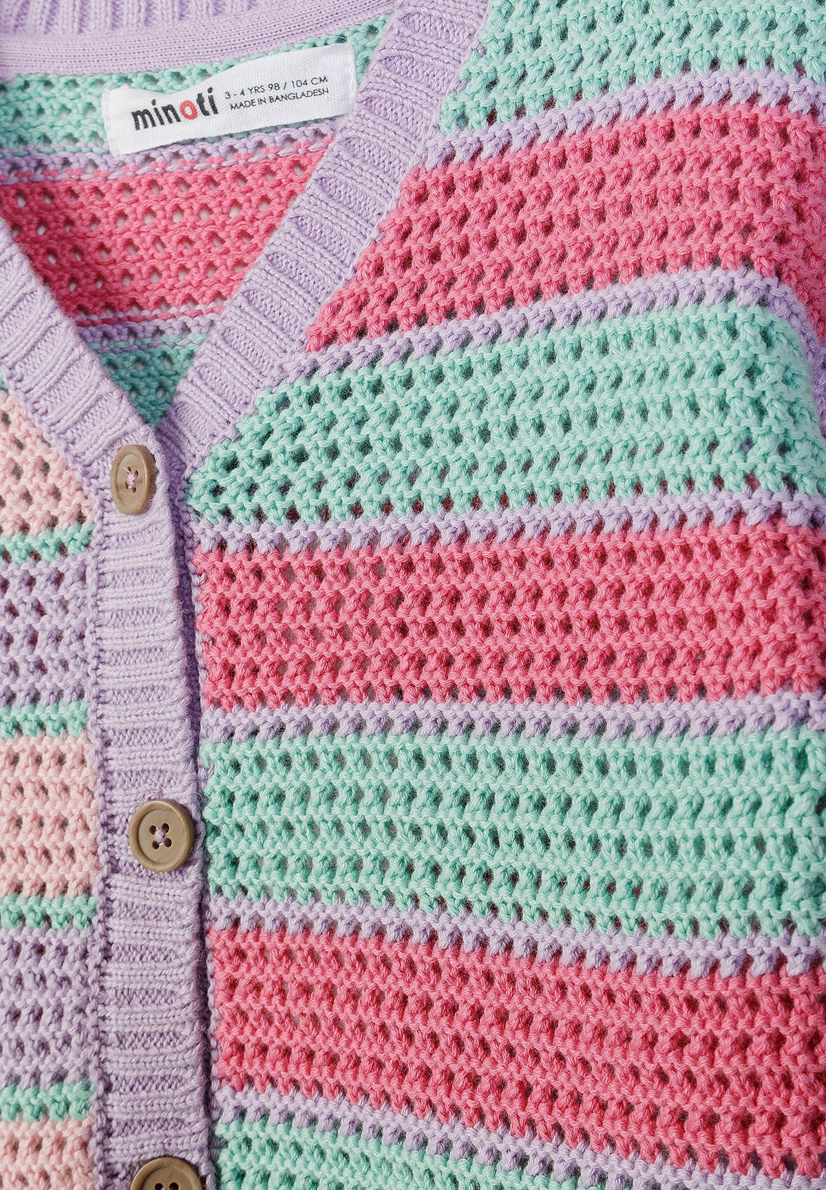 Close-up of pastel cardigan's lilac V-neck, tan buttons and openwork stripes.