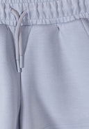 Close-up of elasticated waist and drawstring on light blue girls shorts with soft fabric and neat stitching design.