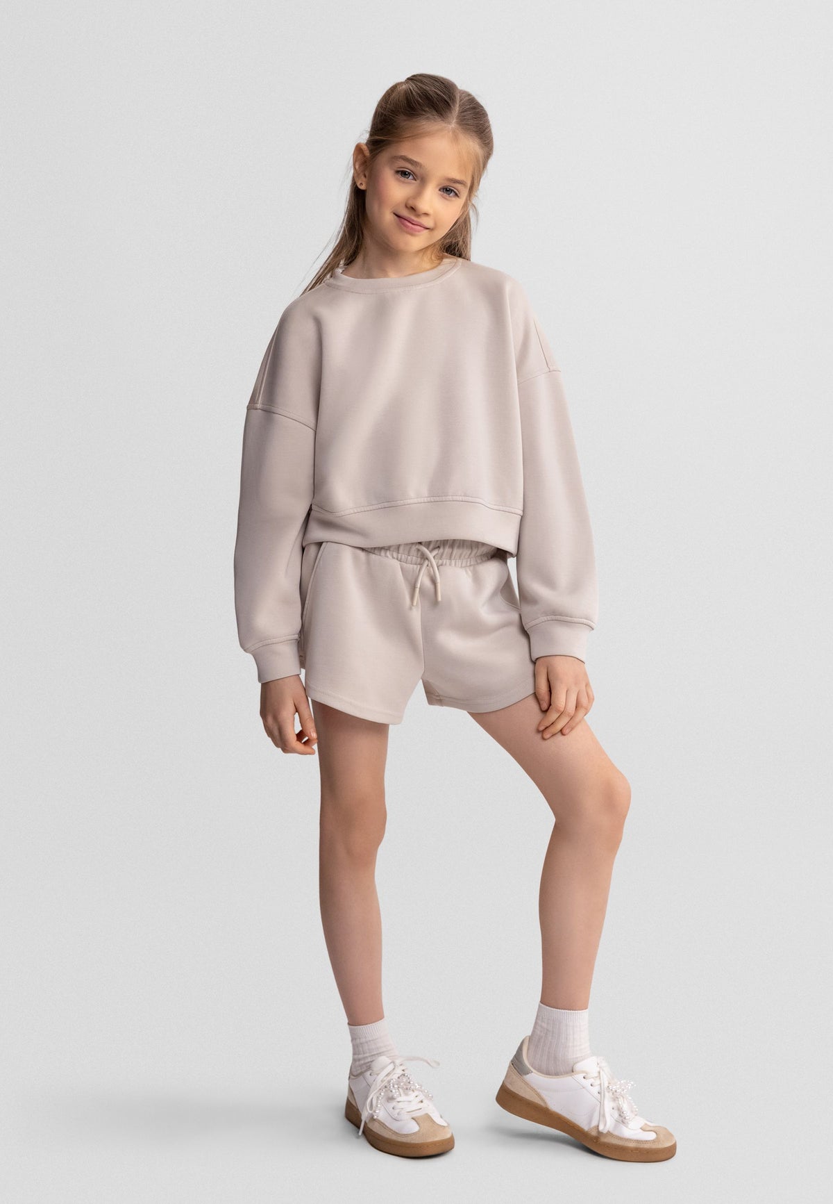 Beige sweatshirt and shorts set, child model front.
