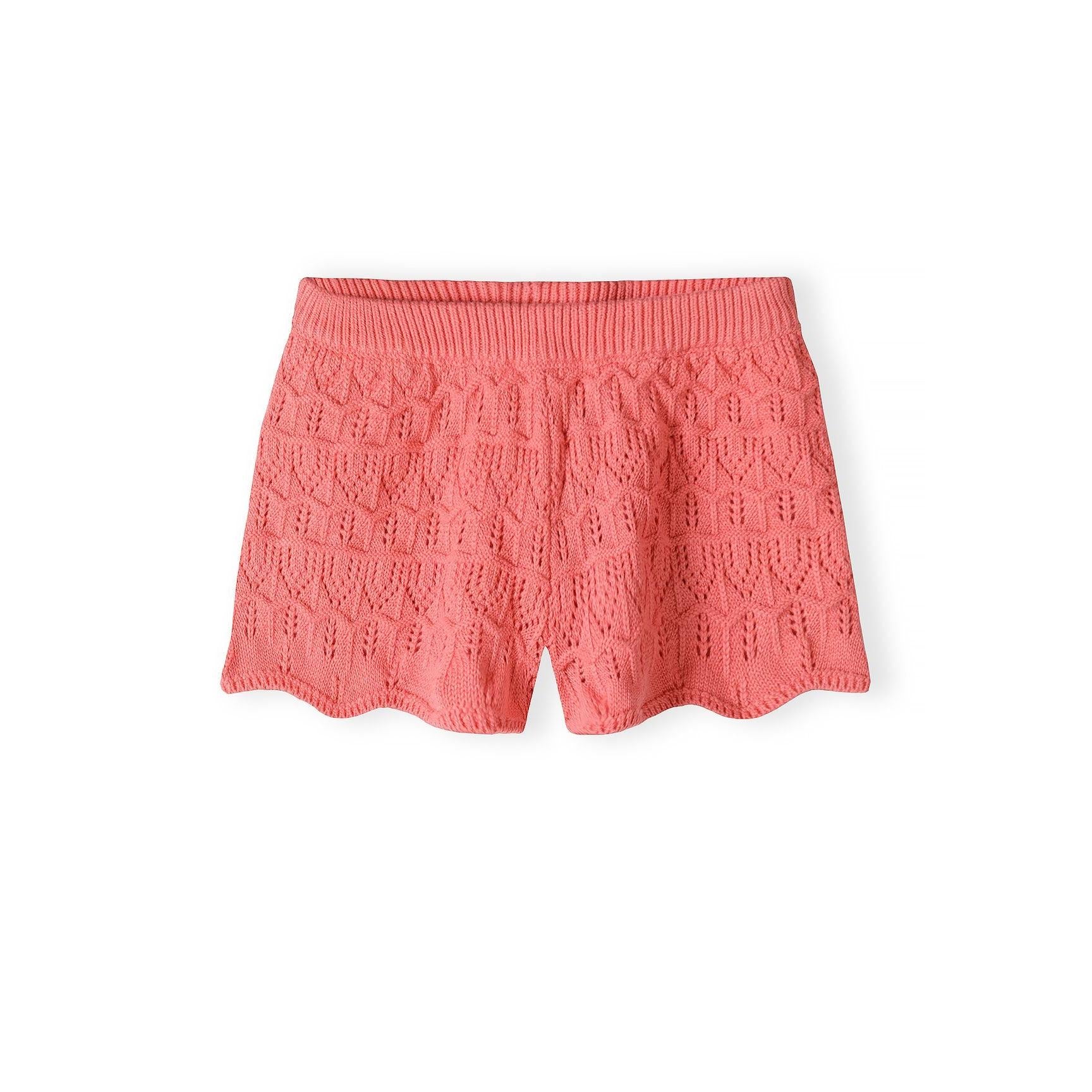 Close-up of coral pink crochet shorts showing elasticated waistband and detailed lace knit texture on white background