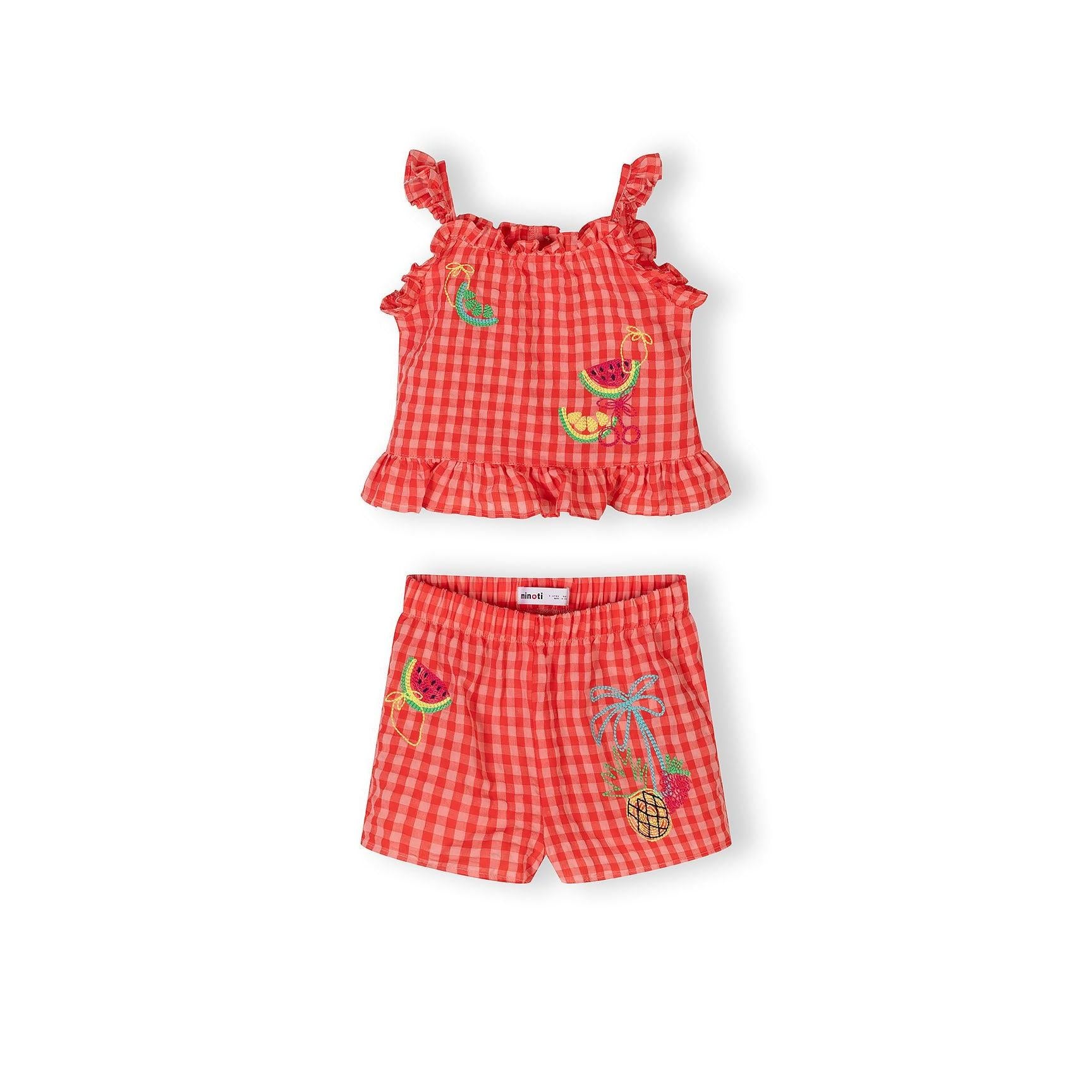 Close-up flat lay of red gingham sleeveless top with ruffle straps and button details on white background