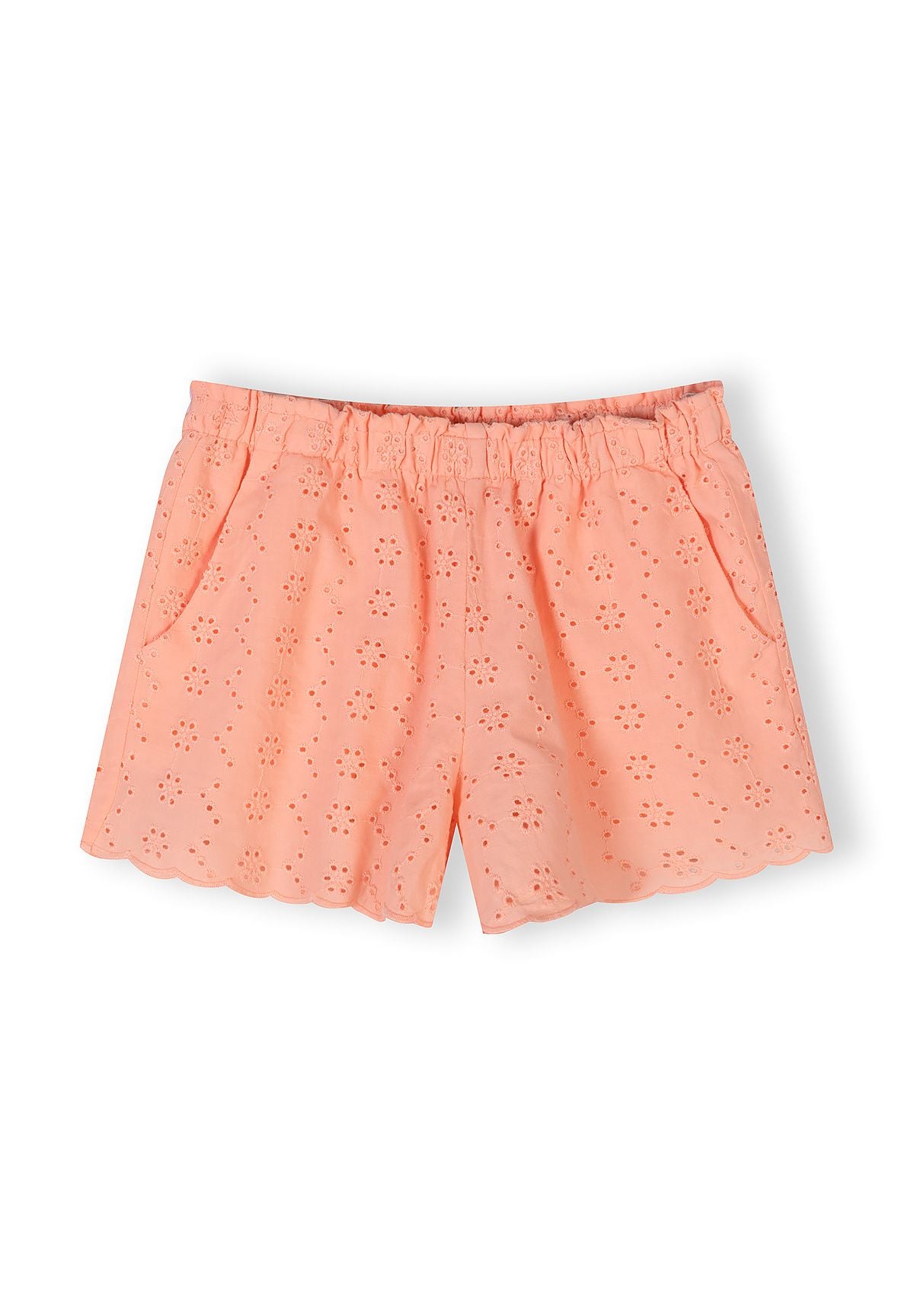 Close-up detail of apricot cotton fabric showing delicate broderie anglaise eyelet embroidery pattern with floral motifs and elasticated waistband