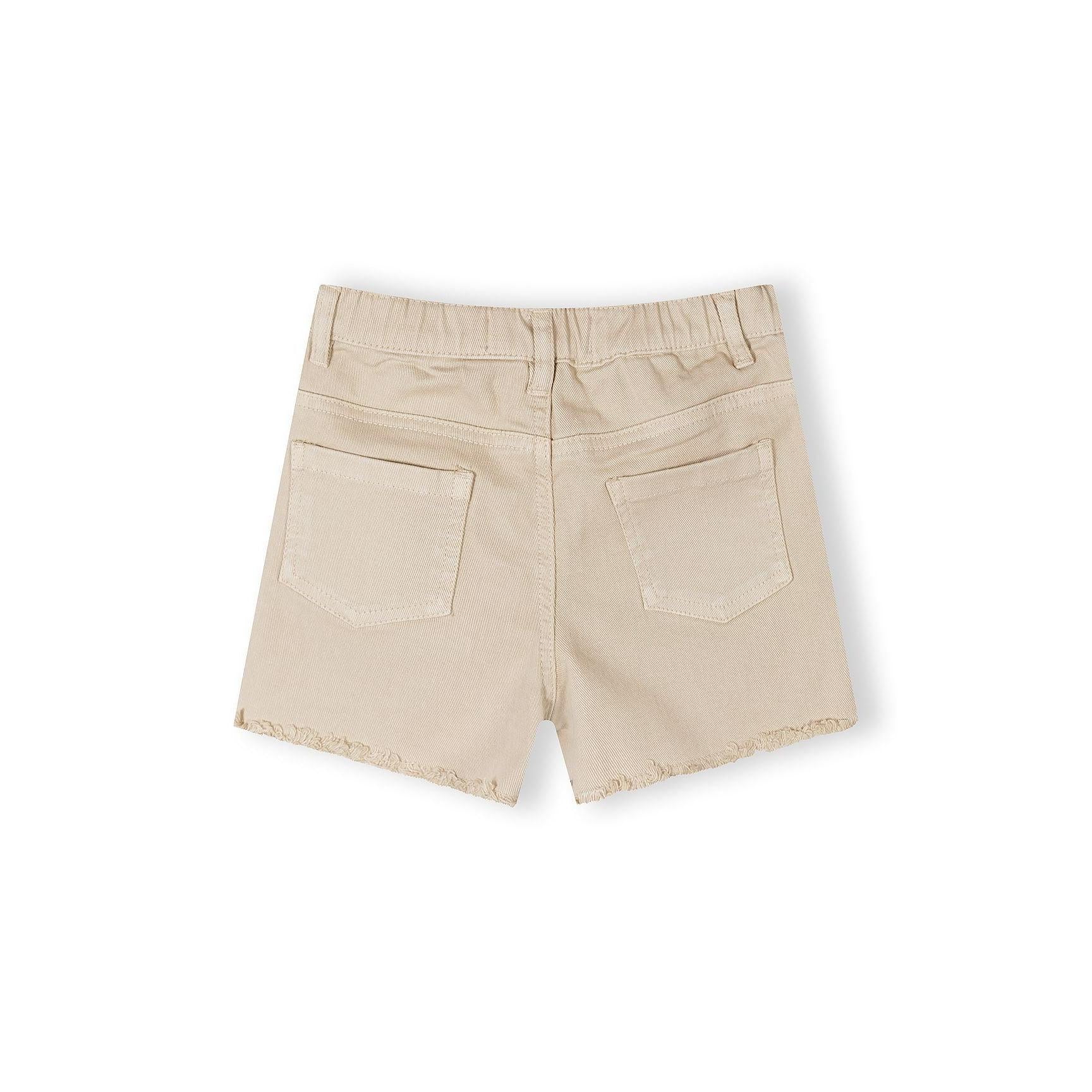 Close-up detail of beige shorts waistband showing Minoti label with size information, button fastening, and classic belt loops on neutral background