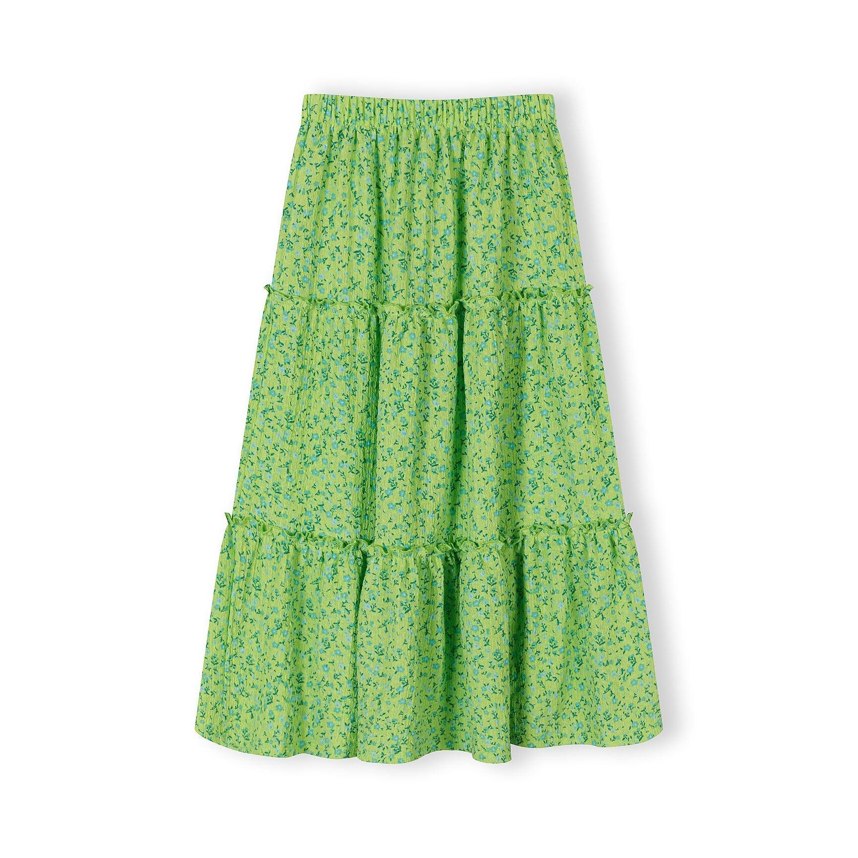 Close-up detail of green floral fabric showing blue and teal flower pattern with gathered ruffle seam and Minoti label