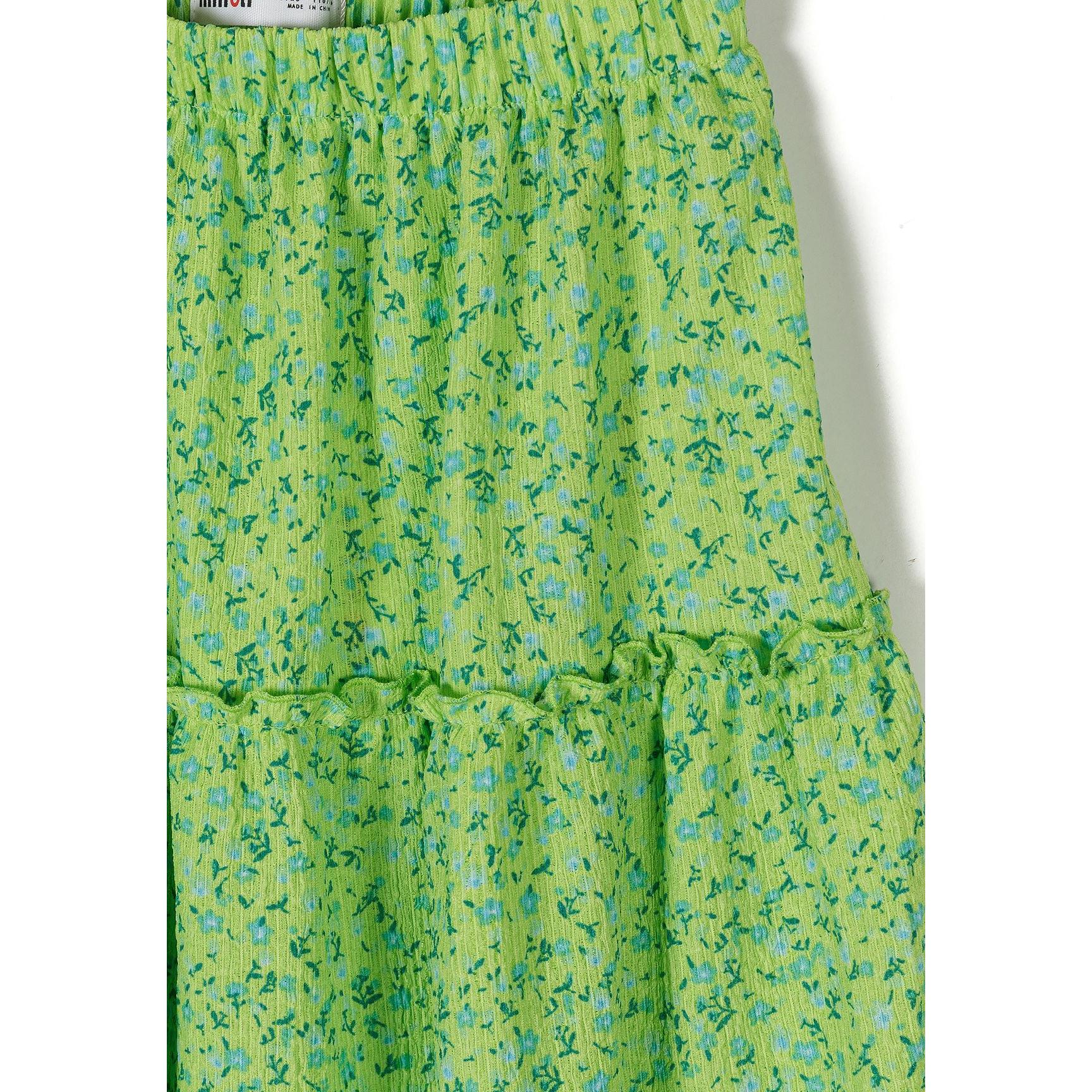 Close-up detail of green floral fabric showing blue and teal flower pattern with gathered ruffle seam and Minoti label