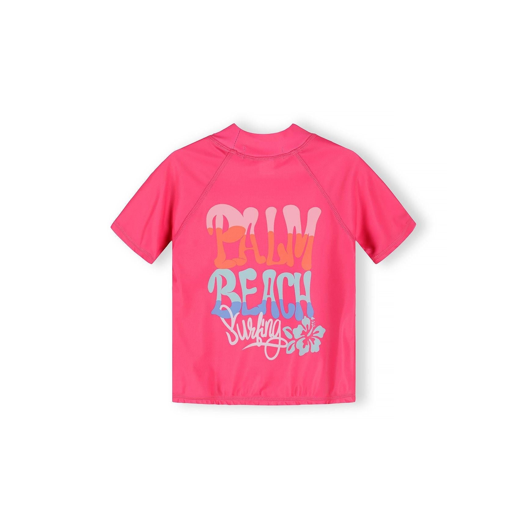 Back view of bright pink rash top showing 'Fun Beach Surfing' text with tropical flower design on white background