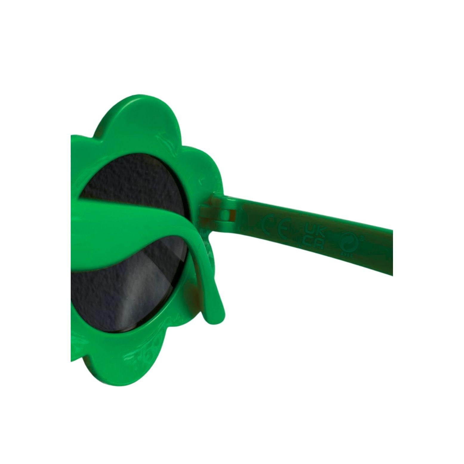 Close-up detail of green flower-shaped sunglasses with dark lenses and curved temple arms