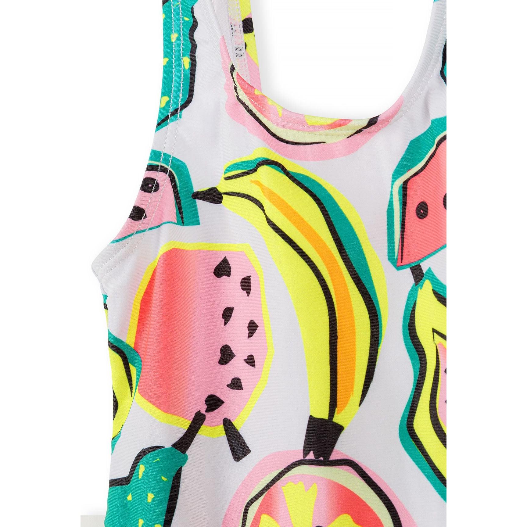 Detailed view of fruit print swimsuit showing watermelon slices with black seeds, yellow bananas, and pineapples on white background fabric