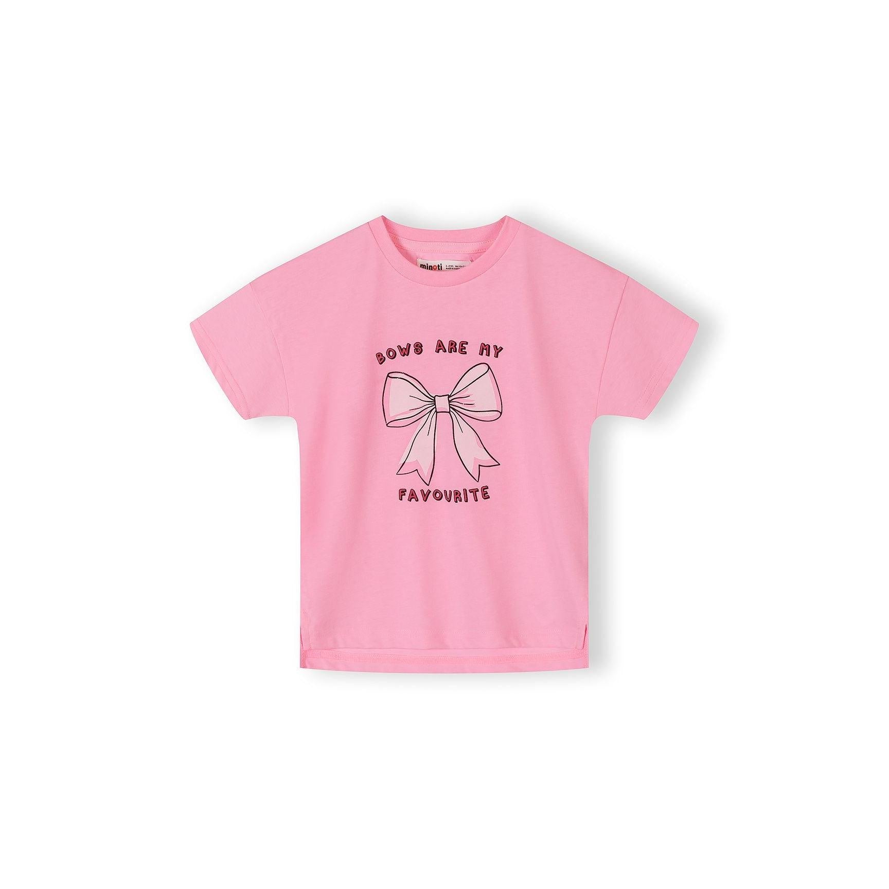 Close-up detail of pink cotton t-shirt fabric showing bow print pattern with blue bows, text elements including 'AWESOME', 'GIRLY', 'COOL' and heart shapes scattered across pink background
