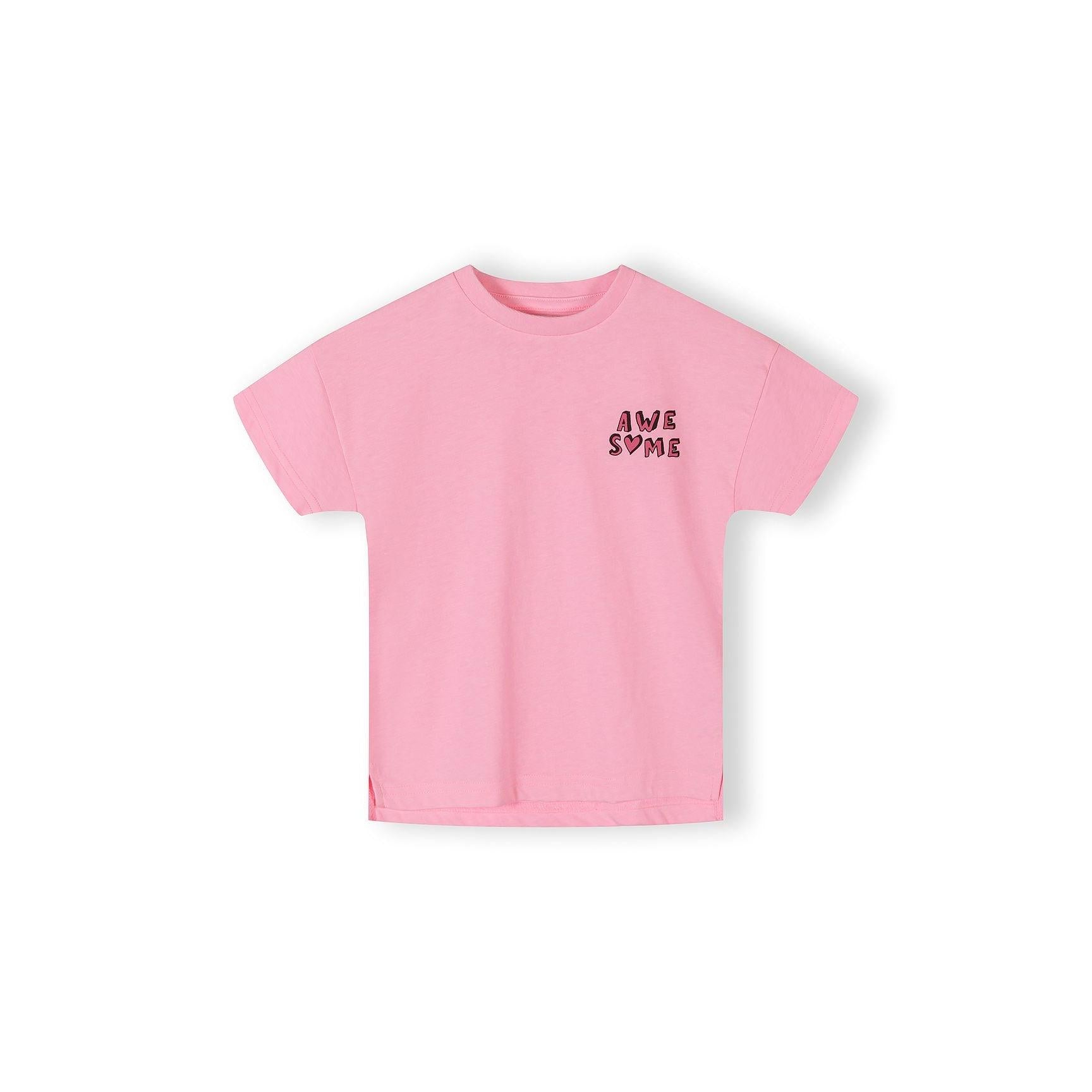 Close-up detail of pink cotton t-shirt fabric showing bow print pattern with blue bows, text elements including 'AWESOME', 'GIRLY', 'COOL' and heart shapes scattered across pink background