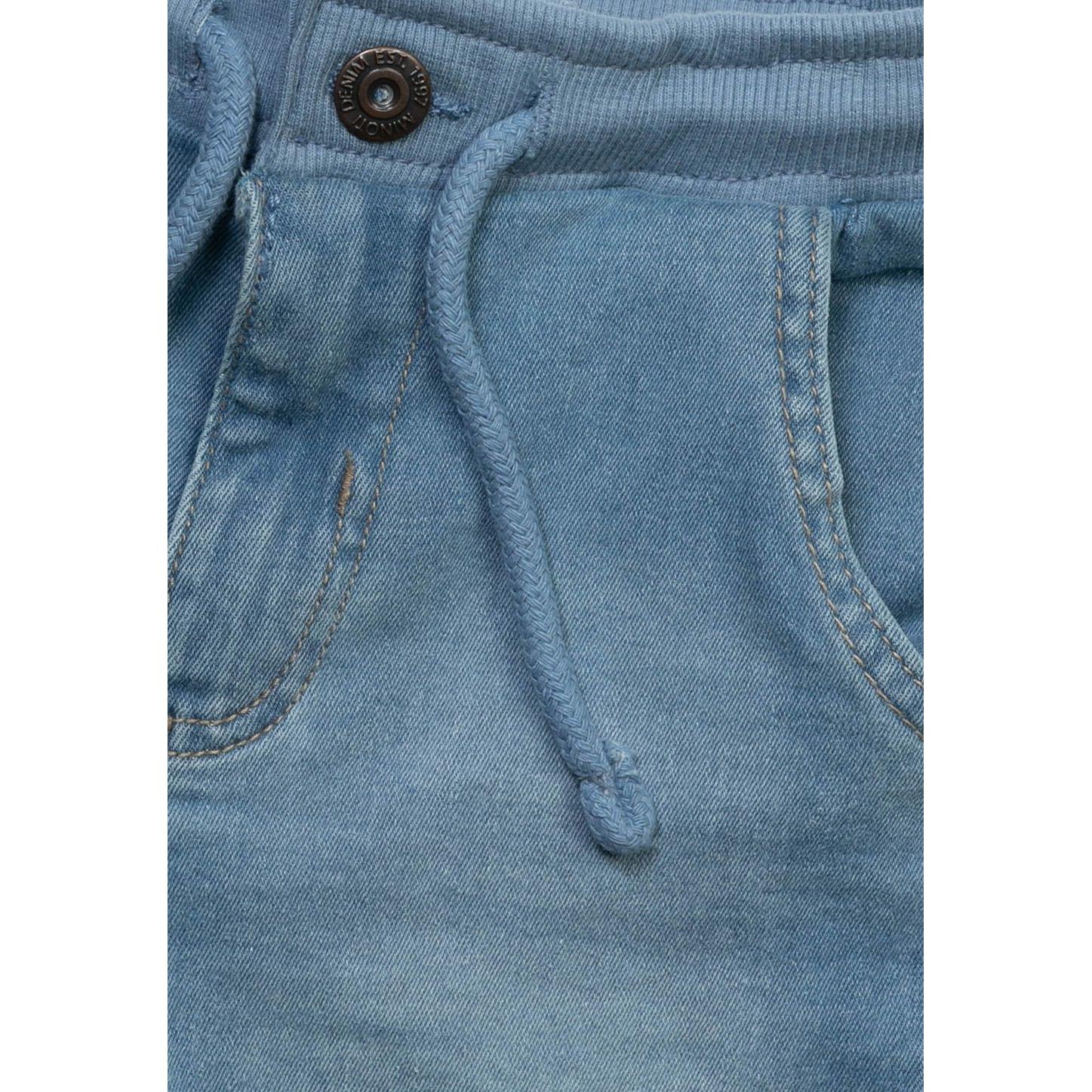 Close-up detail of light blue denim shorts showing drawstring waist, front pocket and button closure with contrasting stitching
