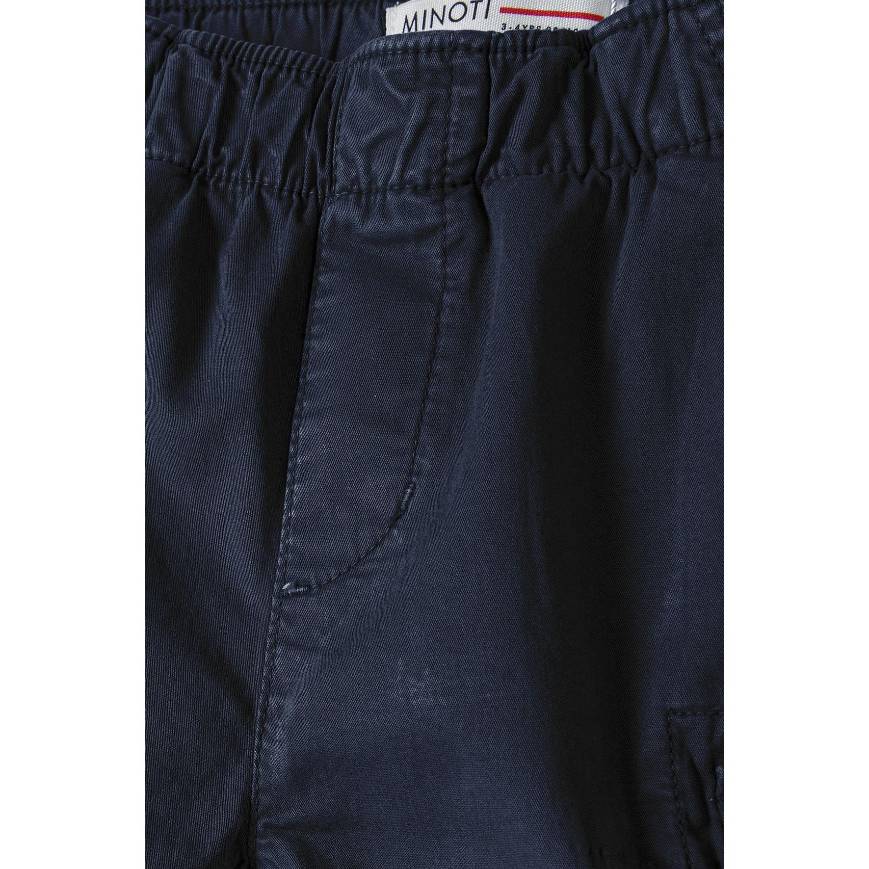 Close-up detail of navy combat shorts showing elasticated waistband construction with white Minoti brand label at the waist