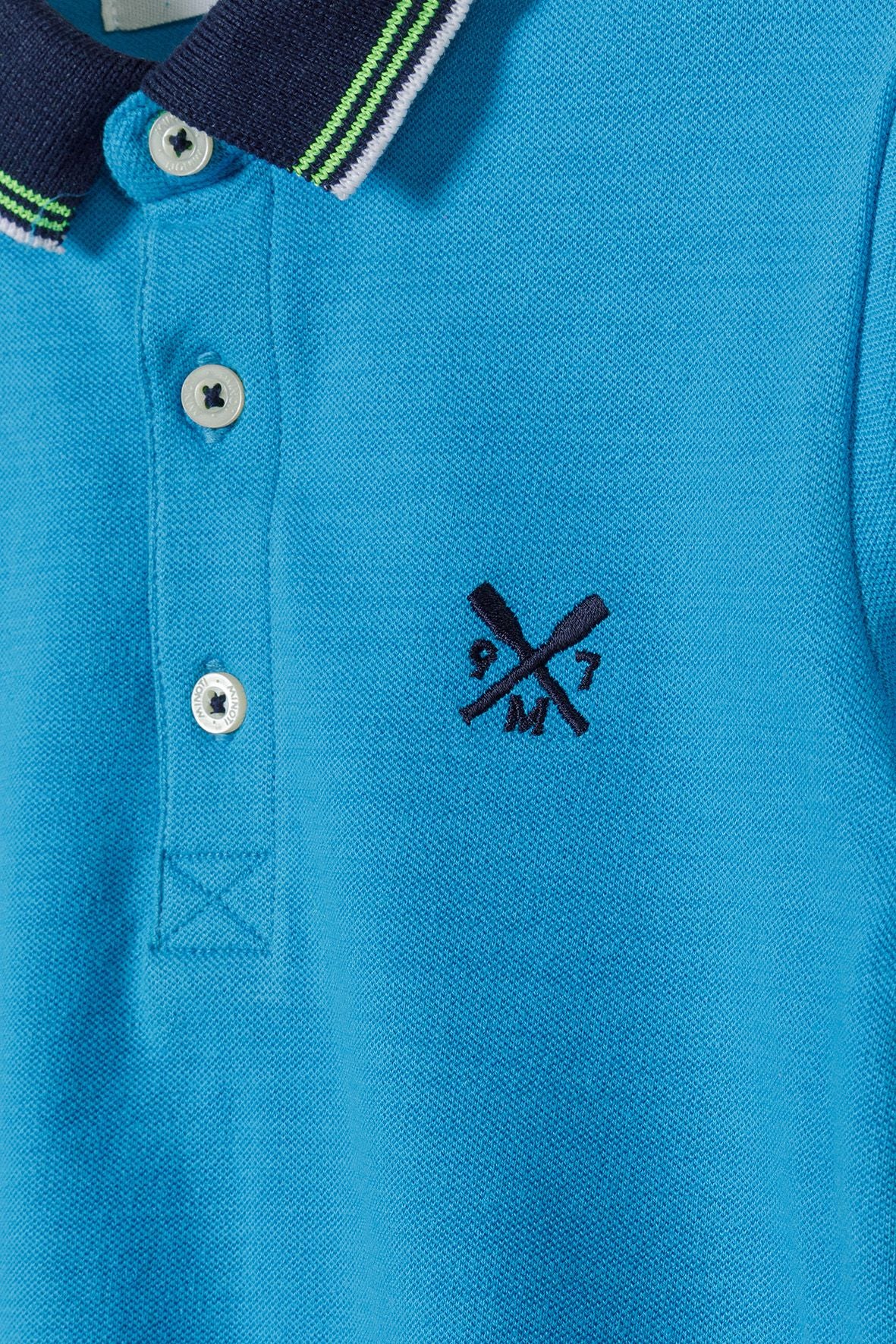 Turquoise and navy polo shirt, collar and placket detail.