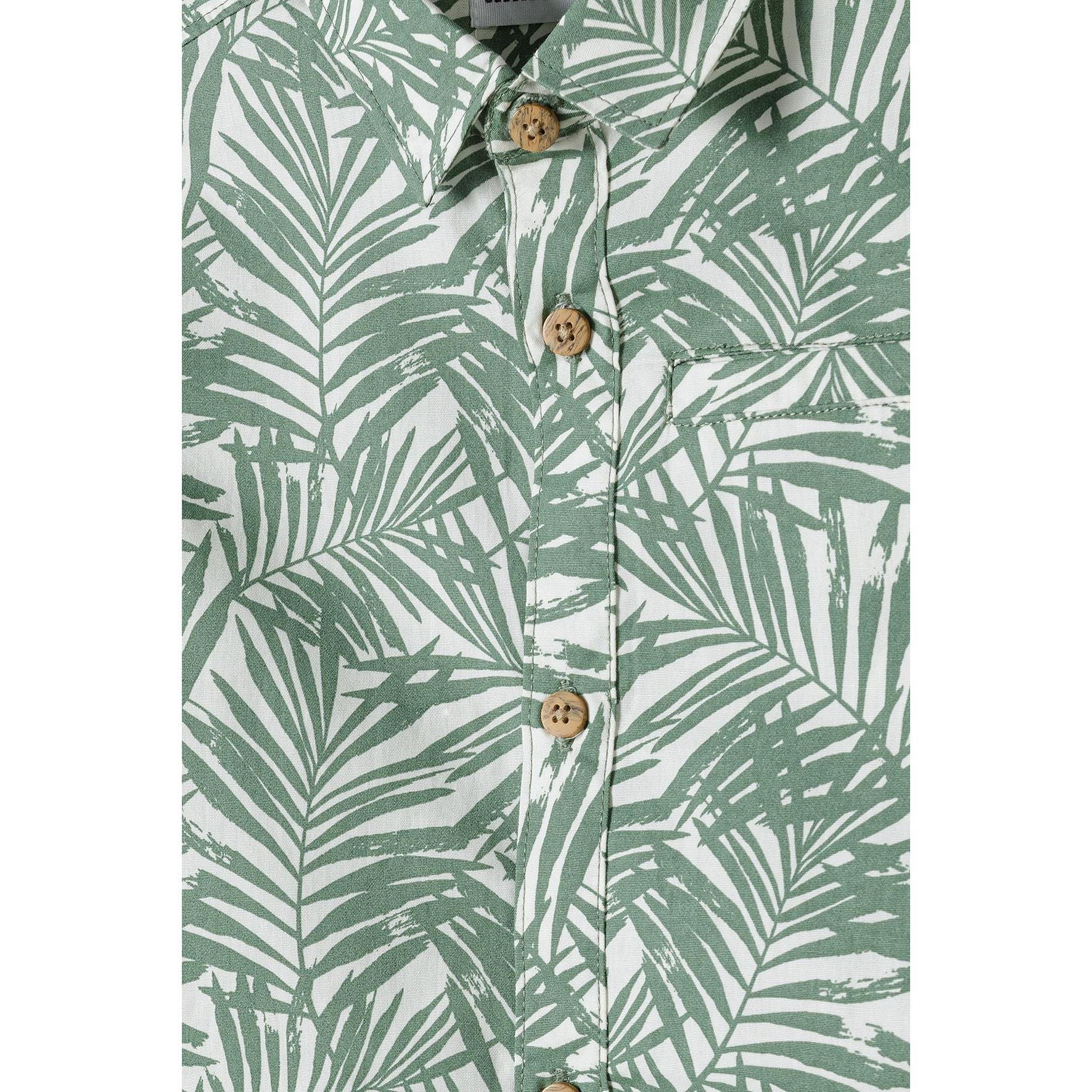 Close-up detail of olive palm print shirt showing natural wooden buttons, collar construction and intricate tropical leaf pattern in green and white