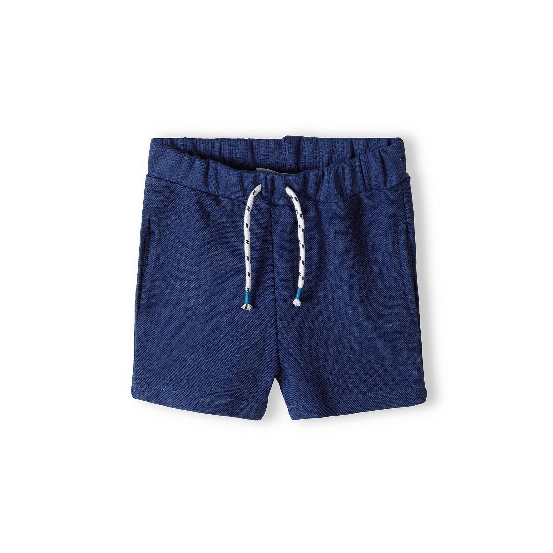 Navy blue shorts laid flat showing elasticated waistband with ruffle detail and comfortable fit design on white background