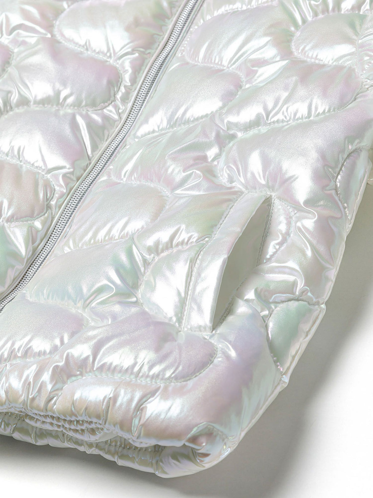 Close-up of the pocket on the white quilted jacket.
