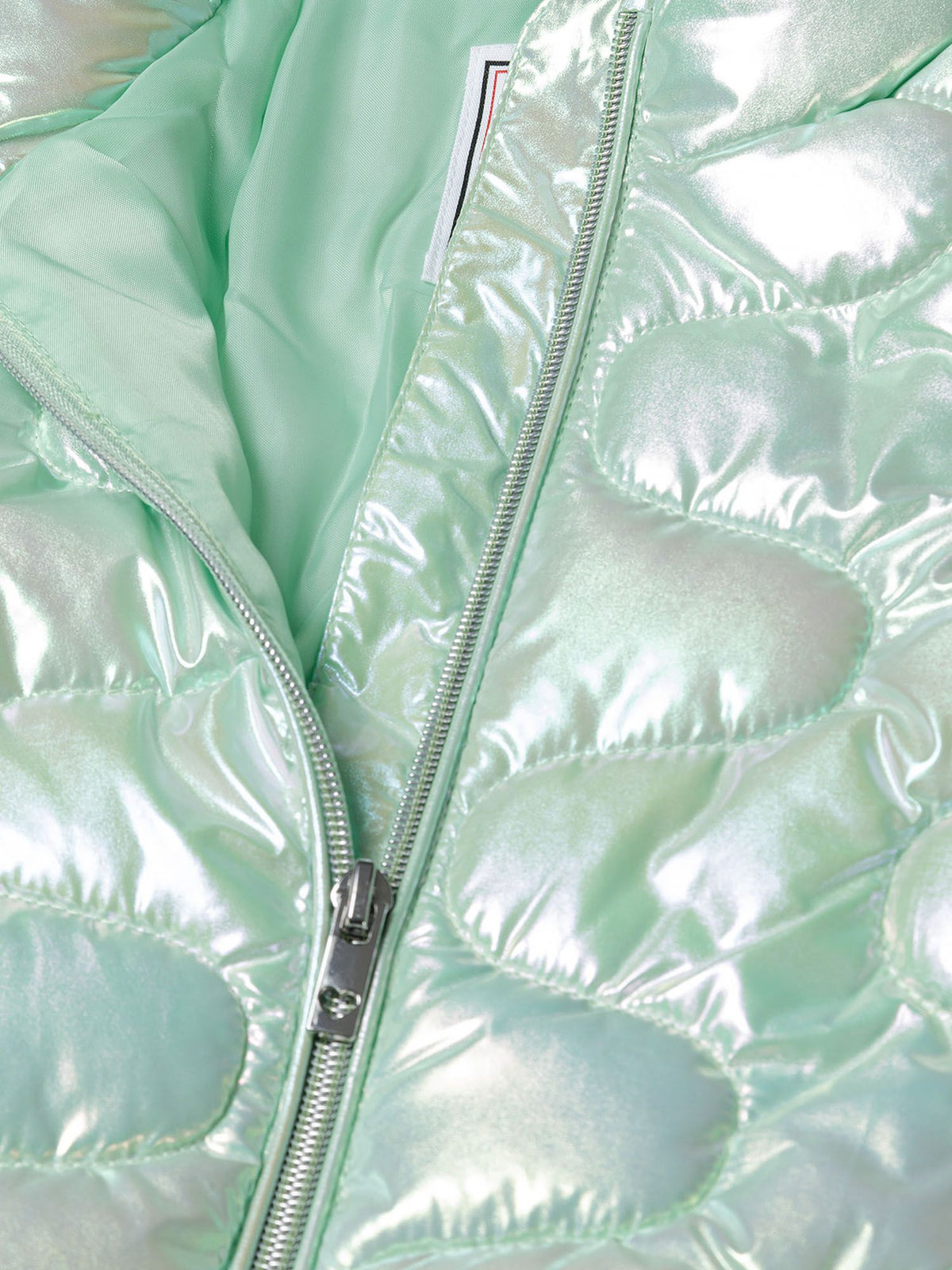 Close-up of the zip and lining on the light green quilted jacket.