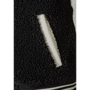 Black sherpa-lined pocket with white ribbed trim on girls baseball jacket
